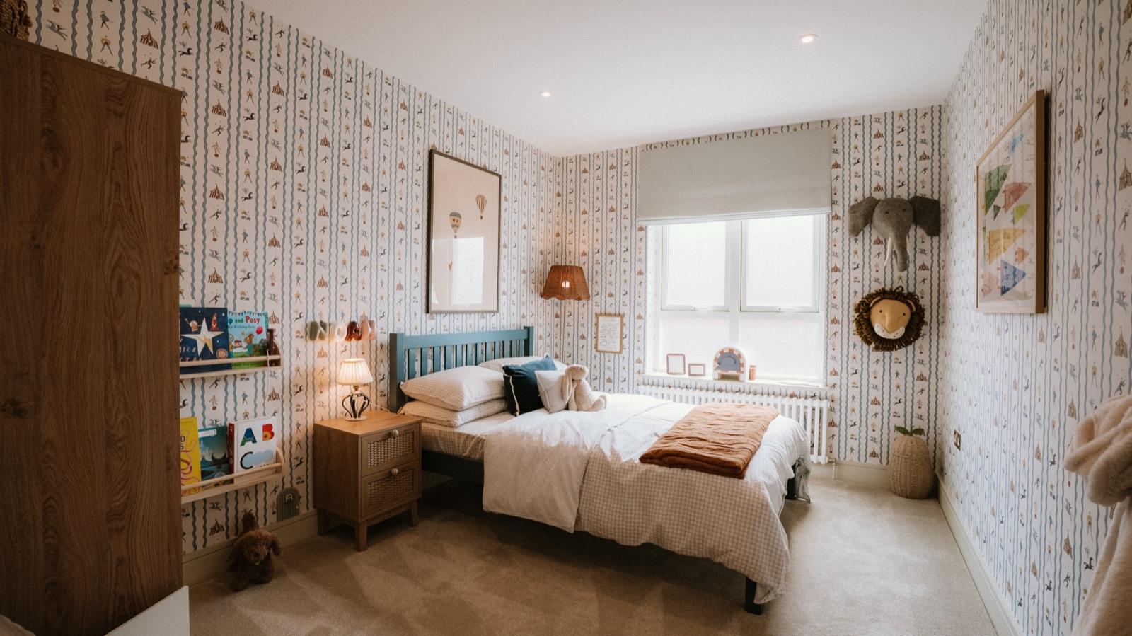 Show home bedroom with patterned wallpaper and blue headboard
